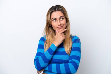 Beyaz arka planda izole edilmiş genç beyaz kadın yukarı bakarken bir fikir düşünüyor.