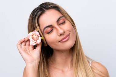 Beyaz arka planda izole edilmiş beyaz bir kadın elinde çiçeklerle. Portreyi kapat