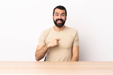 Masada sakallı, yüzünde sürpriz ifade olan beyaz bir adam..