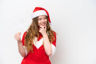 Beyaz arka planda kar taneleri taşıyan beyaz elbiseli, beyaz saçlı genç bir kadın bir fikir üretiyor ve bir tarafa bakıyor.