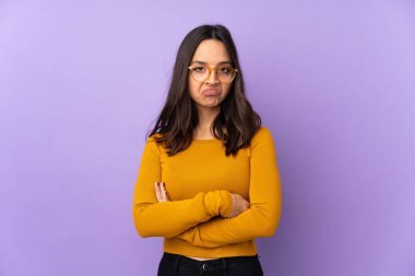 Mor arka planda izole edilmiş genç bir ırk kadını üzgün hissediyor.