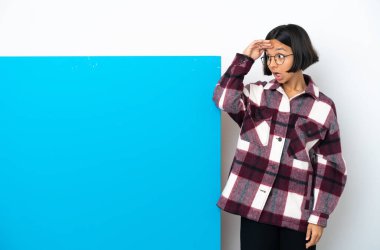 Beyaz arka planda büyük mavi pankartlı, melez bir kadın. Sürpriz bir ifadeyle yan yana bakarken.