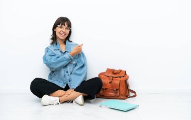 Genç bir bayan, beyaz arka planda izole bir zeminde oturuyor.