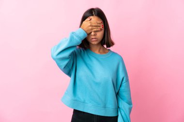 Pembe arka planda izole edilmiş genç Latin kadın gözlerini elleriyle kapatıyor. Bir şey görmek istemiyorum.