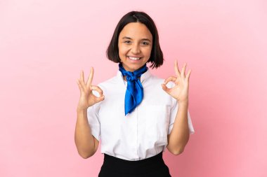 Uçak hostesi izole edilmiş arka planda iki elle tamam işareti gösteriyor.