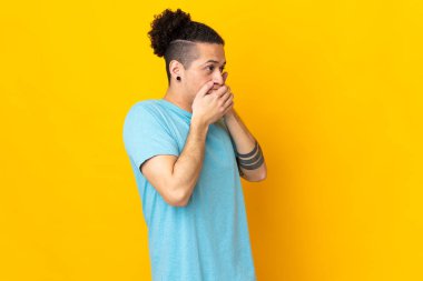İzole edilmiş arka plan üzerinde beyaz bir adam ağzını kapatıyor ve yan tarafa bakıyor.