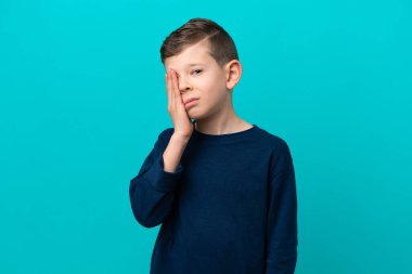 Küçük çocuk mavi arka planda baş ağrısı ile izole edilmiş.