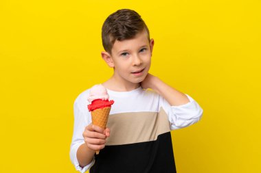 Sarı arka planda izole edilmiş kornet dondurmalı beyaz çocuk gülüyor.