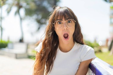 Açık havada genç bir kadın Gözlüklü ve şaşkın bir ifadeyle