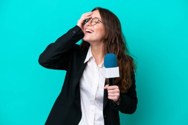 Genç TV sunucusu, mavi arka planda izole edilmiş, gülümseyen bir kadın.