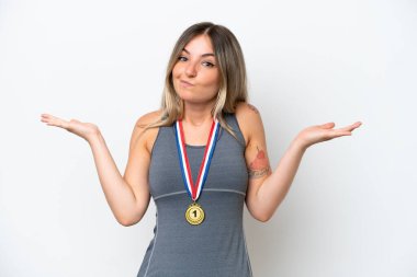 Beyaz arka planda madalyaları olan genç Romen kadın ellerini kaldırırken şüpheye düşüyor