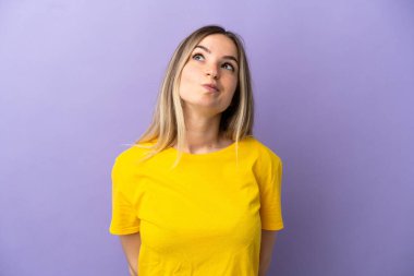 İzole edilmiş mor arka planı olan genç bir kadın.