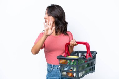 Elinde yiyecek dolu bir sepet tutan genç bir kadın dur hareketi yapıyor ve hayal kırıklığına uğruyor.