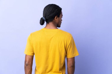 Örgülü genç Afrikalı Amerikalı adam mor arka planda izole edilmiş.