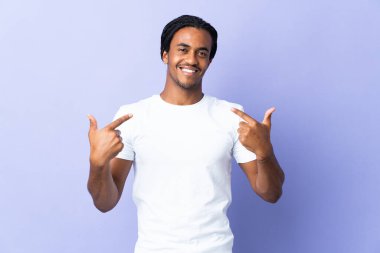 Örgülü genç Afrikalı Amerikalı adam mor arka planda izole edilmiş gururlu ve kendini beğenmiş.