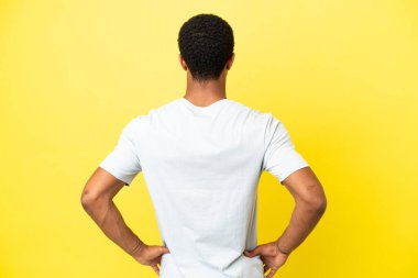 Arkadaki izole edilmiş sarı arka planda Afro-Amerikalı yakışıklı adam.