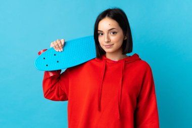 Mavi arka planda paten kayan beyaz bir kadın.