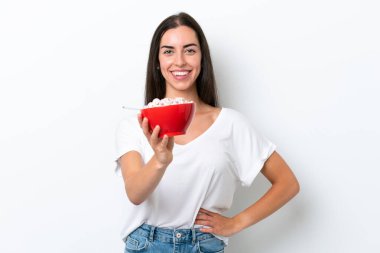 Beyaz arka planda kahvaltı sütü içen beyaz bir kadın. Mutlu bir ifadeyle.