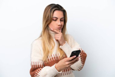 Beyaz arka planda izole edilmiş genç beyaz kadın düşünüp bir mesaj gönderiyor.