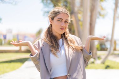 Sarışın, güzel bir Uruguaylı kadın açık havada el kaldırırken kuşkuları var.