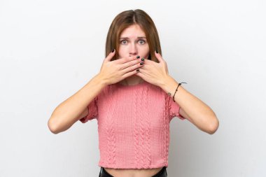 Beyaz arka planda izole edilmiş genç bir İngiliz kadın elleriyle ağzını kapatıyor.