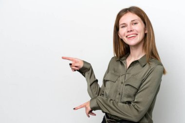 Beyaz arka planda izole edilmiş genç bir İngiliz kadın parmağını yana uzattı ve bir ürün sundu.