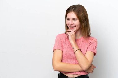 Beyaz arka planda soyutlanmış genç bir İngiliz kadın yan bakıyor ve gülümsüyor.