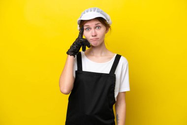 Genç İngiliz balıkçı sarı arka planda izole edilmiş bir fikir düşünüyor.