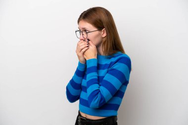 Beyaz arka planda izole edilmiş genç bir İngiliz kadın ağzını kapatıyor ve yan tarafa bakıyor.