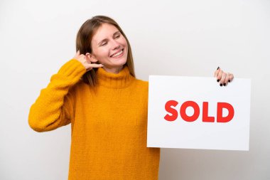 Beyaz arka planda izole edilmiş genç bir İngiliz kadın. Elinde yazılı bir pankart var.