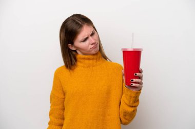 Soda tutan genç İngiliz kadın üzgün bir ifadeyle beyaz arka planda izole edilmiş.