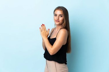 Genç Uruguaylı kadın mavi arka planda bir şeyler planlıyor.