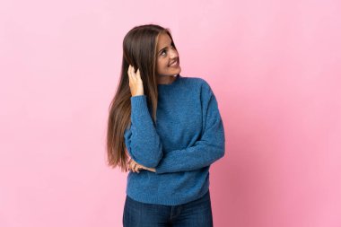 Genç Uruguaylı kadın pembe arka planda izole edilmiş bir fikir düşünüyor.