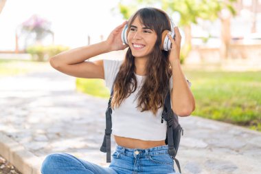 Açık havada müzik dinleyen genç bir kadın