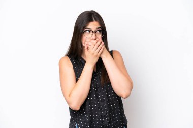 Genç Brezilyalı bir kadın beyaz arka planda izole edilmiş ağzını kapatıyor ve yan tarafa bakıyor.