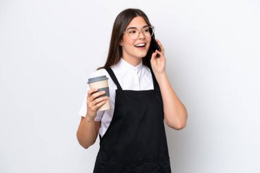 Restoran Brezilyalı garson kadın beyaz arka planda izole edilmiş. Elinde kahve ve cep telefonu var.