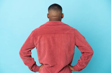 Genç latin adam arka planda mavi arka planda izole edilmiş.