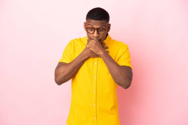 Pembe arka planda izole edilmiş genç Latin adam öksürük ve kötü hissetmekten muzdarip.