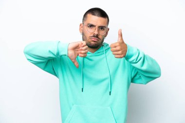 Beyaz arka planda izole edilmiş beyaz bir adam iyiye-kötüye işaret yapıyor. Evet ya da hayır arasında kararsız