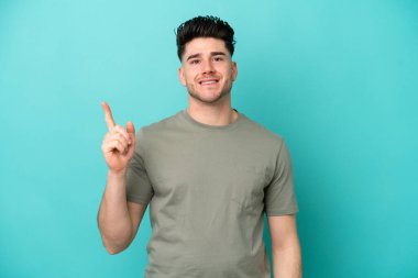 Kafkasyalı genç adam mavi arka planda izole edildi.