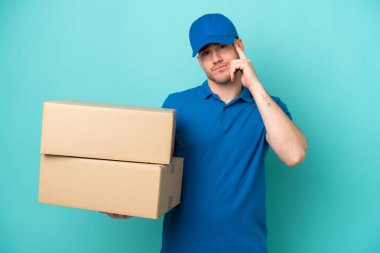 Teslimat yapan beyaz adam mavi arka planda izole edilmiş bir fikir düşünüyor.