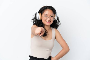 Beyaz arka planda izole edilmiş genç Asyalı kadın müzik dinliyor.