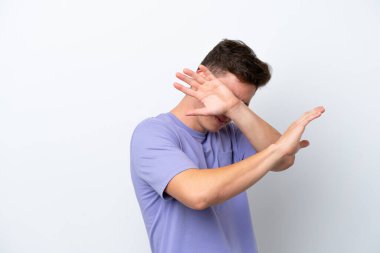 Genç ve yakışıklı Brezilyalı bir adam beyaz arka planda izole edilmiş gergin eller öne doğru uzanıyor.