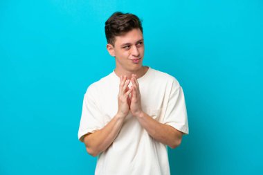 Young handsome Brazilian man isolated on blue background scheming something
