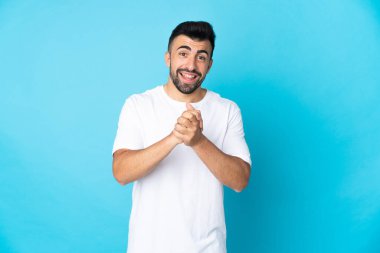 İzole edilmiş mavi arka planı olan beyaz bir adam gülüyor.