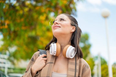Açık havada genç ve güzel bir kadın. Mutlu bir ifade.