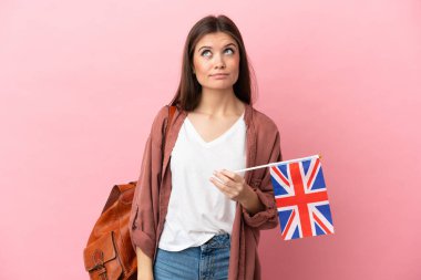 Pembe arka planda Birleşik Krallık bayrağı taşıyan beyaz bir kadın var.