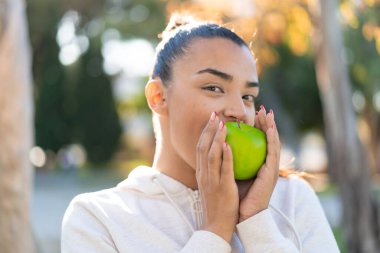 Elma tutan genç ve güzel bir bayan.