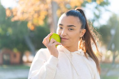 Elma tutan genç ve güzel bir bayan.