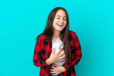 Mavi arka planda izole edilmiş genç Ukraynalı kadın çok gülümsüyor.